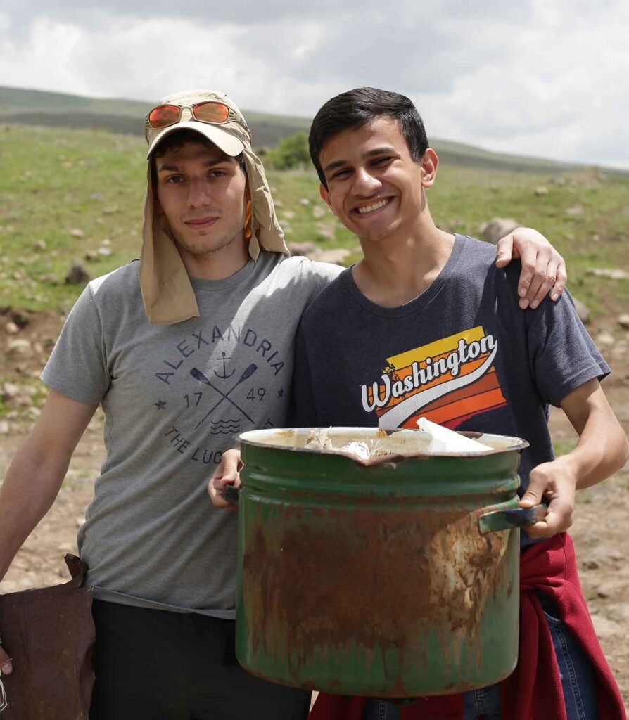 Gevorg Ghazaryan and a volunteer carrying a bin of collected trash during a Maqoor Environmental clean-up hike in the Geghama Mountains, Armenia